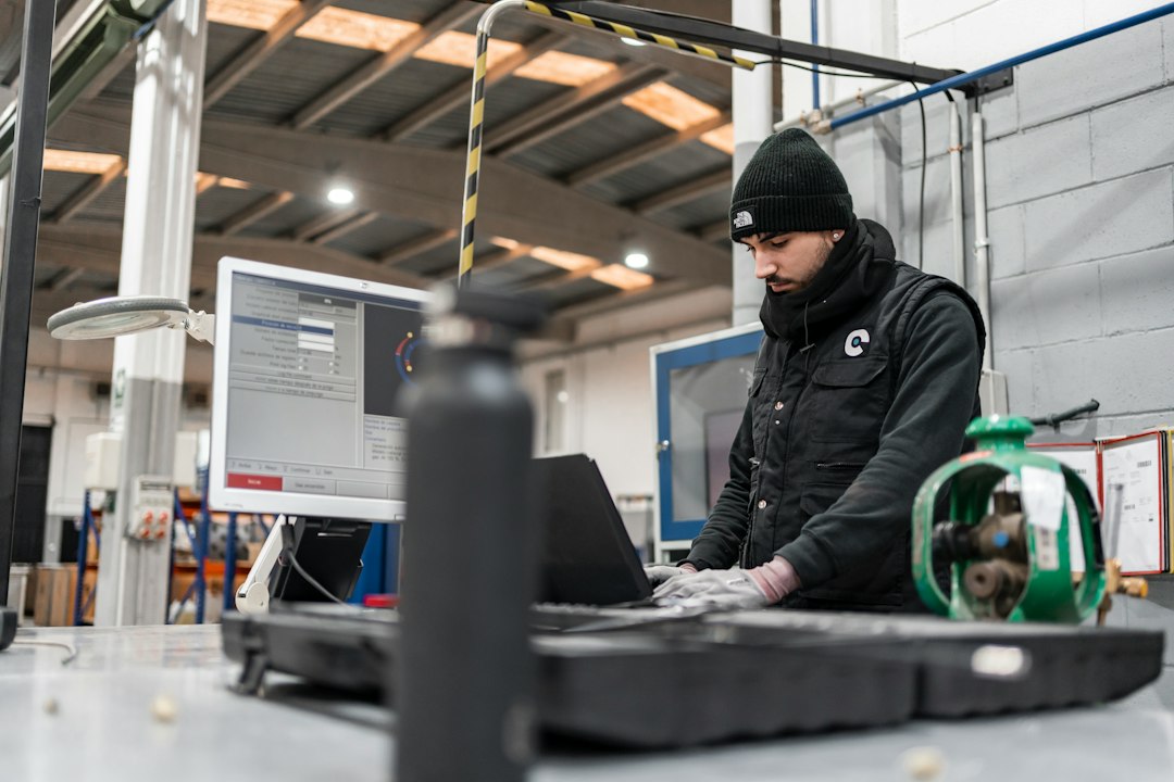 Man works on a computer in a manufacturing setting