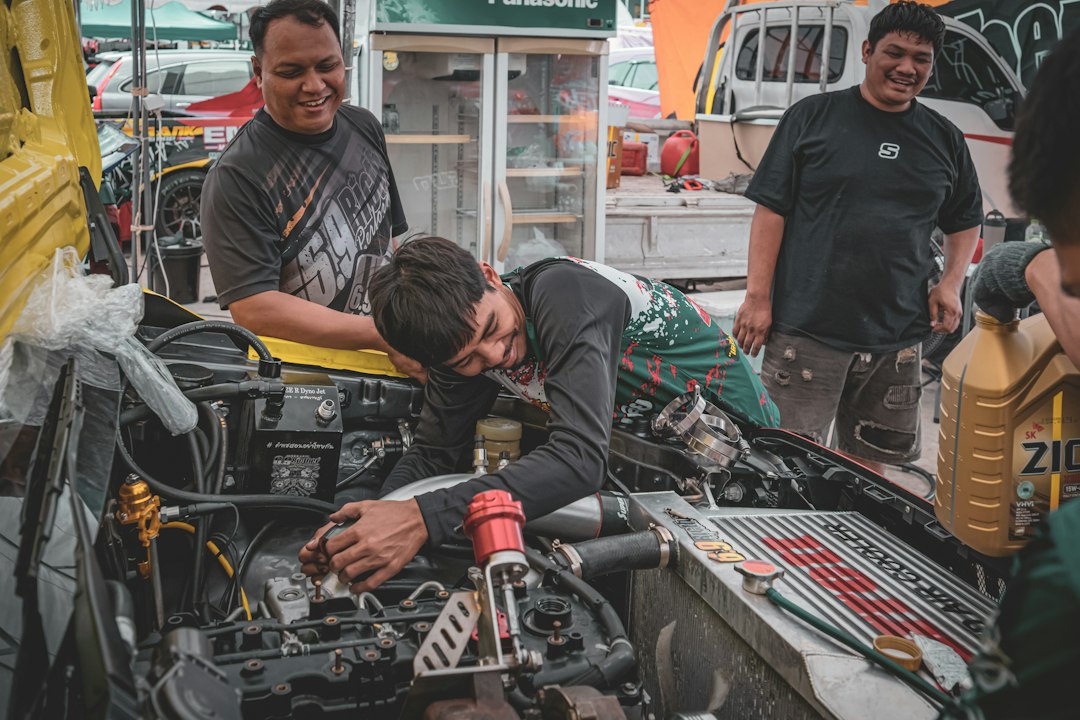 Men working on a car engine outdoors