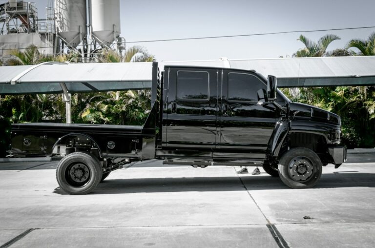 a black truck parked in front of a factory
